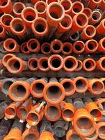 a pile of orange pipes with the words water supply on the bottom. photo