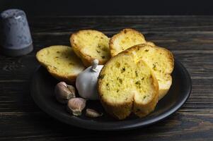 bread with garlic and garlic on a black plate photo