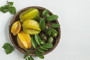 fresh star fruit and green leaves in a basket photo