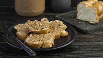 a plate of bread with peanut butter and a jar of peanut butter photo