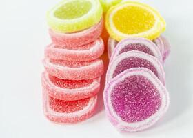 a pile of colorful jelly candies on a white surface photo