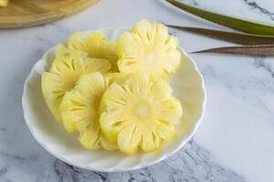 a bowl of sliced pineapple on a marble counter photo