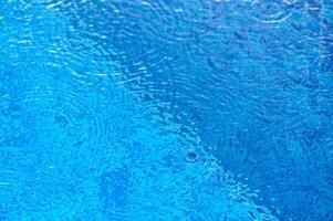 De-focused blurred transparent blue colored clear calm water surface texture with splashes and bubbles.8 photo