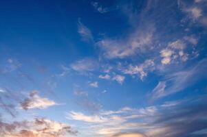 Pastel light cirrus clouds in the blue sky during dawn sunset sunrise, sky background photo