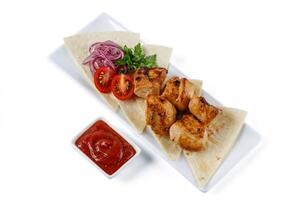 Chicken kebab skewers on a plate over light grey slate, stone or concrete background . Top view with copy space.1 photo