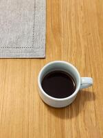 Cup of pure coffee on wooden table in top view. photo