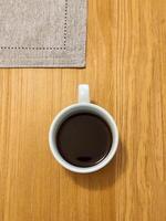 Cup of pure coffee on wooden table in top view. photo