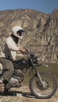 fuori strada motociclista nel deserto paesaggio con roccioso montagne nel sfondo su un' soleggiato giorno video