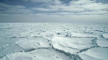 A vast expanse of frozen ocean showing signs of cracks and melt patches caused by the hair dryer winds video