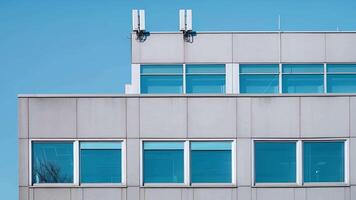 een bescheiden kantoor gebouw met Nee ramen maar met meerdere antennes uitstekend van de dak suggereren verborgen toezicht technologie binnen. video