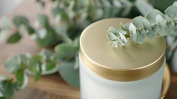 A handpoured soy wax candle in a frosted glass jar topped with a gold lid and emitting a stunning rosewood scent video