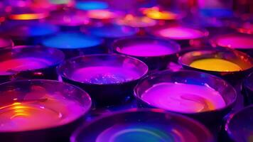 A table covered in bowls of neon paint ready for guests to create their own glowing masterpieces on canvas video