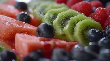 detailopname van een kleurrijk fruit schotel met vers bessen sappig watermeloen en gesneden kiwi geserveerd Bij een nuchter zondag leuke dag bijeenkomst video