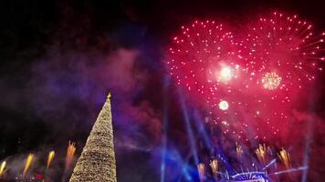 tolle Nacht Öffnung Zeremonie von Junior Eurovision 2022 auf Dezember 5, schön Farbe Feuerwerk Über Weihnachten Baum, Neu Jahr Baum Beleuchtung Zeremonie 2023 Konzept. 4k Aufnahmen video