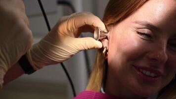 otolaryngologist conducts medical examination of ear with otoscope closeup video