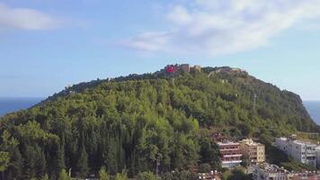 ANKARA, TURKEY - FEBRUARY 25, 2022. Top view of a city in Turkey on a hill during the day. CLIP. A beautiful suburb in the forests with a Turkish flag. Filmed on a quadcopter from above video