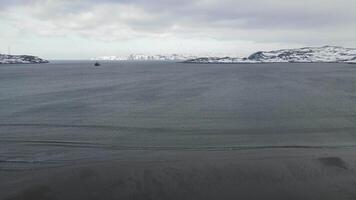 inverno aéreo voar topo sobre ondas rolando em artic oceano costa com volta pedras, oceano ondas às tempestade, 4k Alto qualidade zangão às inverno video