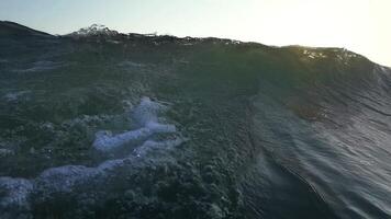 super lento movimento embaixo da agua do oceano onda e areia às lindo pôr do sol. filmado em alta velocidade cinema Câmera às 1000 fps super lento movimento video