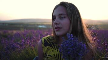 hermosa joven mujer granjero olfatea manojo de lavanda flores en campo a lavanda granja en puesta de sol video