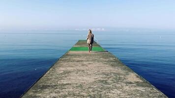 Geschäftsfrau Spaziergänge zu Meer beim alt verlassen Seebrücke im Mode Stil Geschäft klassisch Kostüm. hoch Qualität 4k roh Aufnahmen video