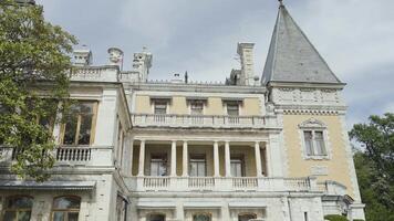 skön Krim slott. handling. vorontsov slott är belägen på de bergen Nästa till skön grön små buskar och träd på en klar blå himmel bakgrund. video