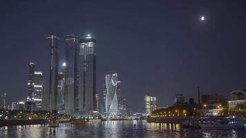 Moscow 2021. Action. Beautiful huge evening buildings near the river in Moscow were shot from afar on a dark evening with bright lights and lanterns that glow . video