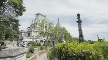 Summer historic palace situated in Sevastopol, Crimea. Action. Concept of architecture, beautiful ancient building surrounded by green bushes on cloudy sky background. video