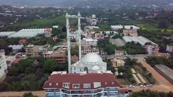 topo Visão do a cidade durante a dia. grampo. uma lindo subúrbio com uma branco mesquita. filmado em uma quadcopter a partir de acima. chalé Vila dentro a montanhas video