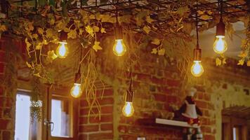 Beautiful hanging bulbs in the loft cafe. Stock footage. Barista making beverage at the coffee shop. video