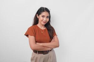 Confident Asian woman standing with arms folded and looking at the camera isolated over white background. photo