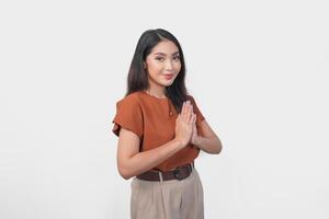 Smiling young Asian woman gesturing formal traditional greeting isolated over white background. photo