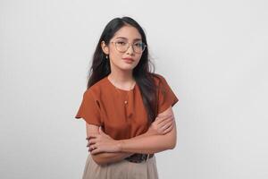 Young Asian woman standing with arms folded and looking at the camera with confident expression isolated over white background. photo