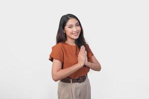 Smiling young Asian woman gesturing formal traditional greeting isolated over white background. photo