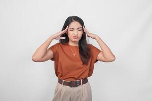 Thoughtful young casual girl wearing a brown shirt making serious expression isolated over white background. photo