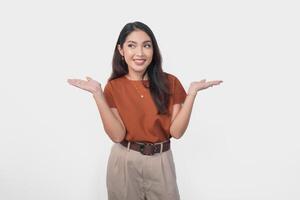 Happy Asian woman is smiling and presenting the copy space beside her over isolated white background. photo