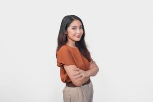 Smiling Asian woman in brown t-shirt standing with confidence expression and looking at the camera isolated over white background. photo