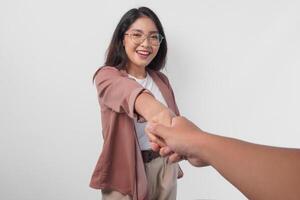 Happy Asian woman smiling and shaking hands with guest or client doing business, isolated by white background. photo