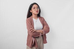 Smiling young Asian woman wearing eyeglasses standing with arms folded with confident expression isolated over white background. photo