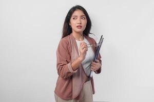 Stylish Asian woman wearing eyeglasses holding document while doing a chic and elegant pose isolated by white background. photo