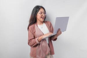 sonriente joven asiático negocio mujer sentado abajo y participación un ordenador portátil abierto terminado aislado blanco antecedentes. foto