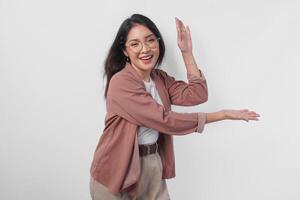 Excited Asian woman wearing eyeglasses presenting the copy space on her right and left side isolated by white background. photo