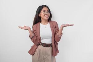 Excited Asian woman wearing eyeglasses presenting the copy space on her right and left side isolated by white background. photo