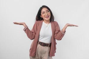 Excited Asian woman wearing eyeglasses presenting the copy space on her right and left side isolated by white background. photo