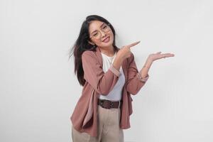 Smiling Asian woman presenting and pointing to the copy space beside her over isolated white background. photo