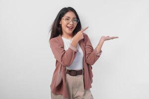 Smiling Asian woman presenting and pointing to the copy space beside her over isolated white background. photo