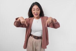 Happy young Asian woman presenting and pointing downwards the copy space, isolated on white background. photo