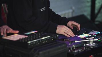 Two DJs are mixing music on console. Art. People are setting up music console. The guy with the tattoos turns knobs on the music mixer video