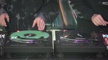 DJs play records at the disco. Art. Close-up of DJ's hand on the mixer. Glowing music panel at a party. The work of musicians in a nightclub video