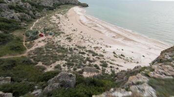 The view from the drone. Action. View of the beautiful green mountains next to the sea on which there is a temple, tall trees, roads and a beach video