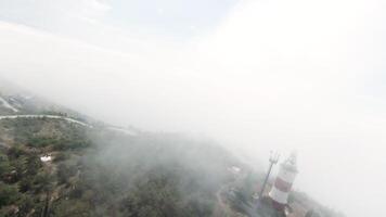 Aerial view of hilly green region with heavy fog above. Action. Fog and clouds and the mountains, beauty of nature. video